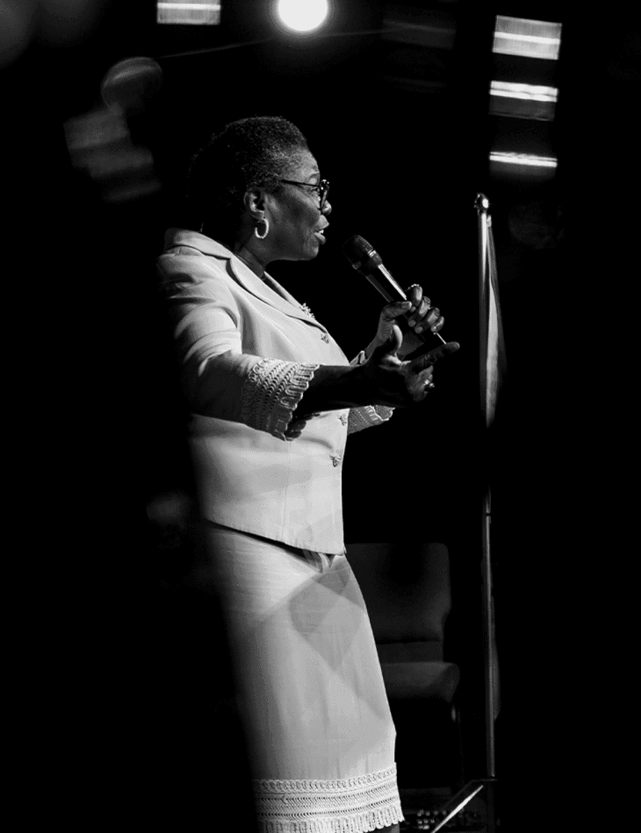 A woman minister delivering a powerful message under dramatic lighting