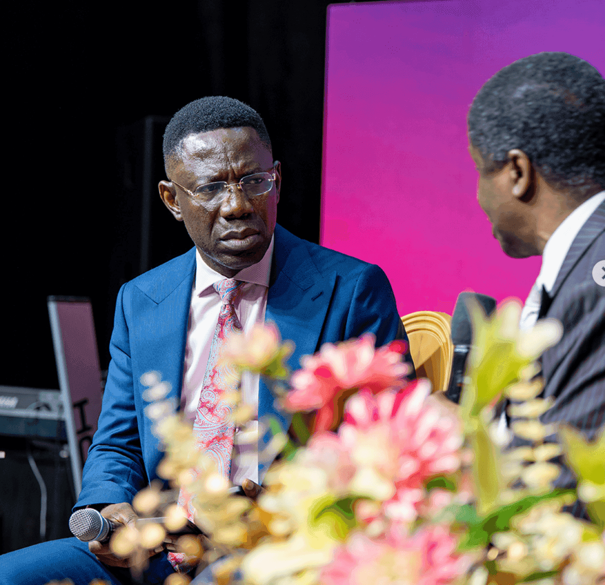 David Abioye listening intently during a session, with flowers in the foreground